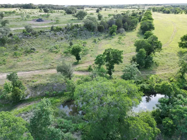 an aerial view of residential houses with outdoor space and trees