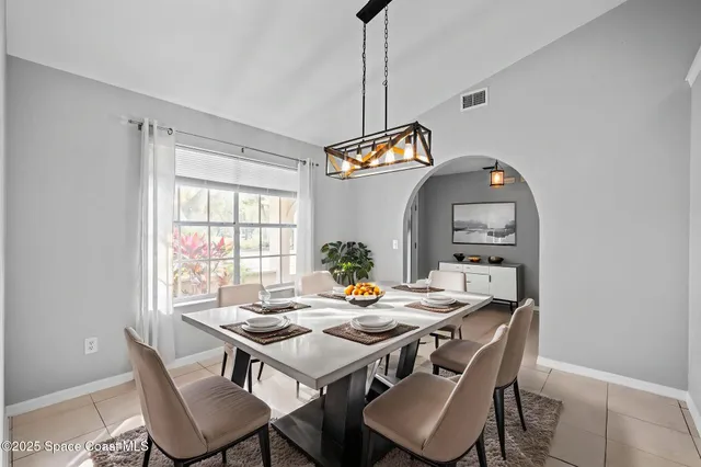 an empty room with windows fireplace and a ceiling fan