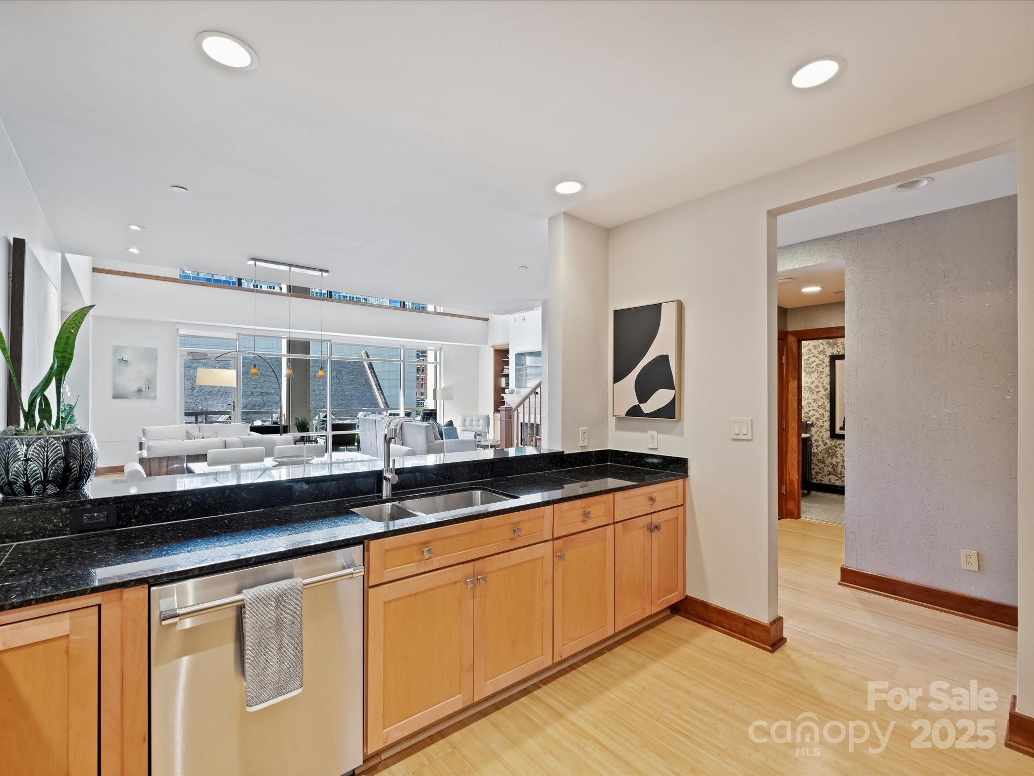 435 South Tryon Street, Unit 307 Charlotte, NC 28202 - Photo 12 of 48 a dining hall with stainless steel appliances granite countertop a sink and dishwasher with wooden floor