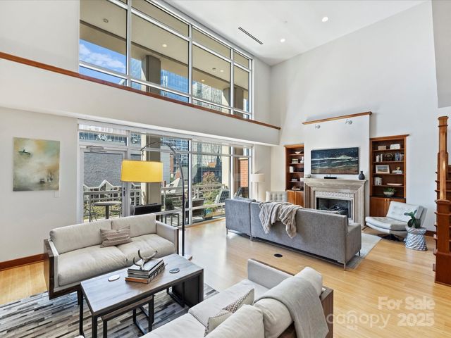 a living room with furniture a fireplace and a large window