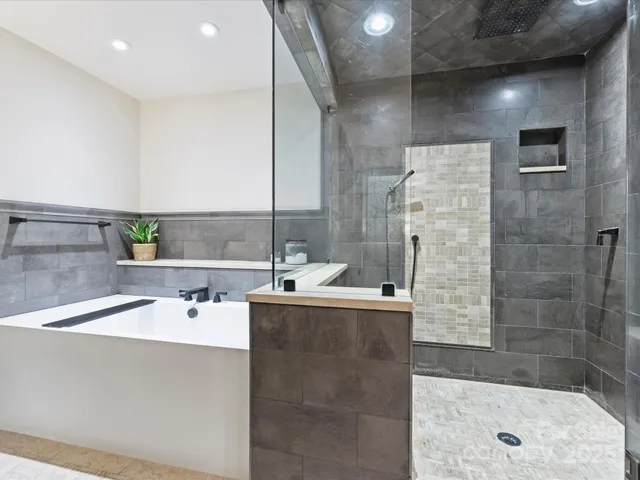 a bathroom with a tub sink and mirror