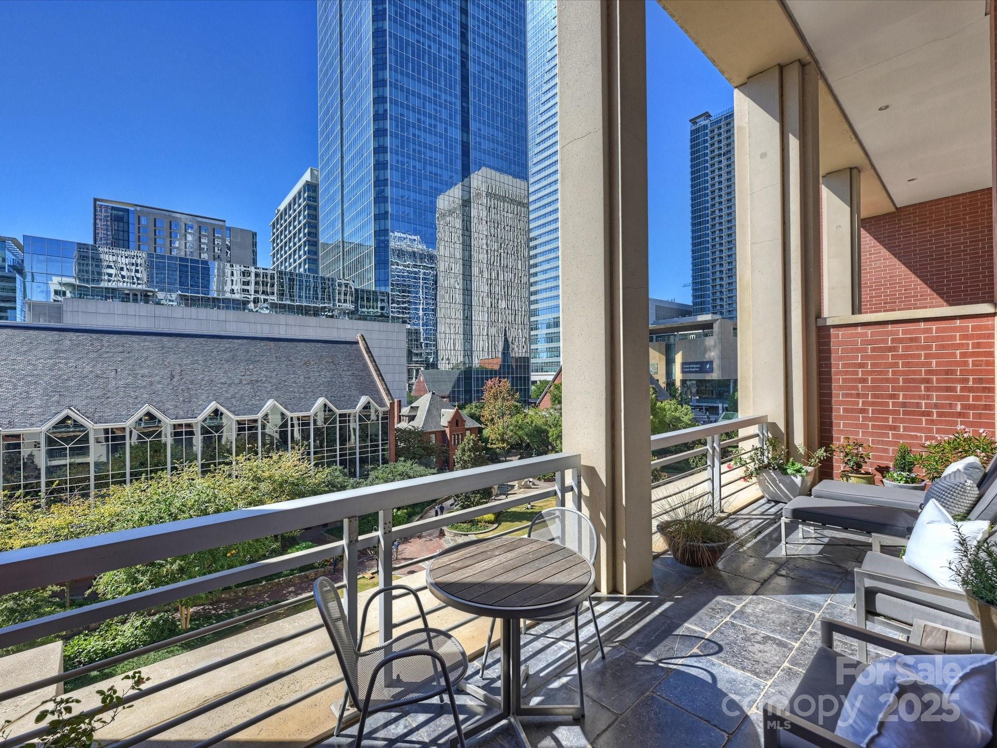 435 South Tryon Street, Unit 307 Charlotte, NC 28202 - Photo 40 of 48 a view of a balcony with chairs and wooden fence
