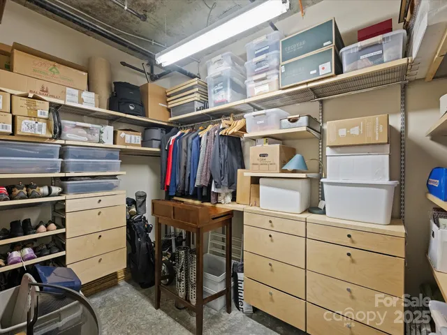 a view of walk in closet with clothes and shoes