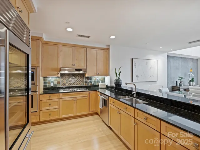 a kitchen with stainless steel appliances granite countertop a sink stove and refrigerator