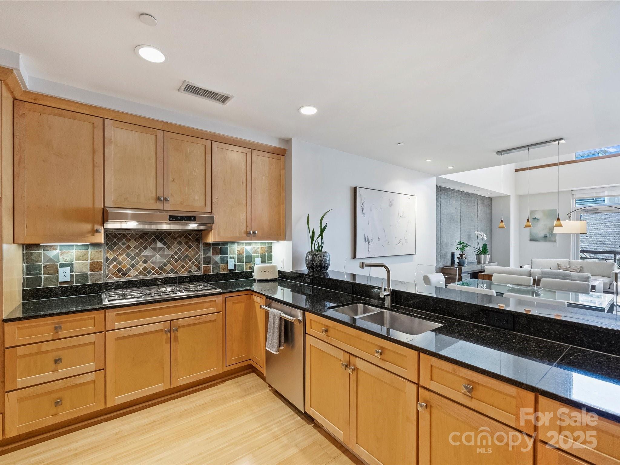 435 South Tryon Street, Unit 307 Charlotte, NC 28202 - Photo 10 of 48 a kitchen with granite countertop a sink and cabinets