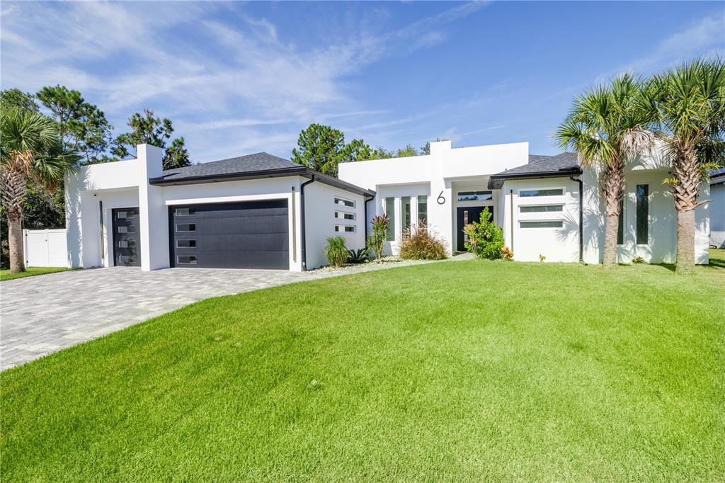 6 Rockne Lane Palm Coast, FL 32164 - Photo 4 of 24 a front view of a house with a garden and plants