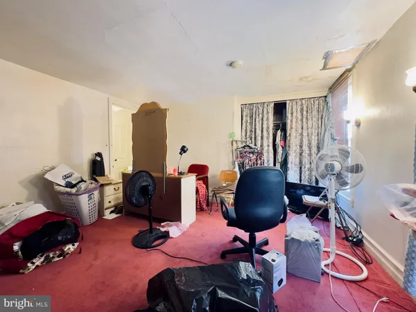 a living room with furniture hard wood floor and a floor to ceiling window