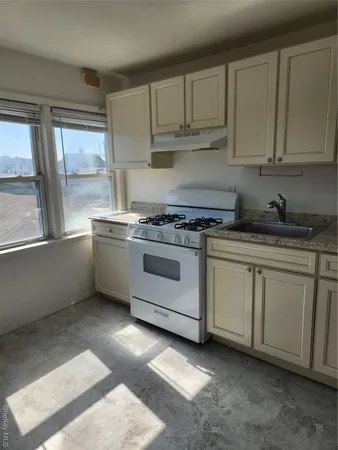 a kitchen with granite countertop white cabinets and white appliances
