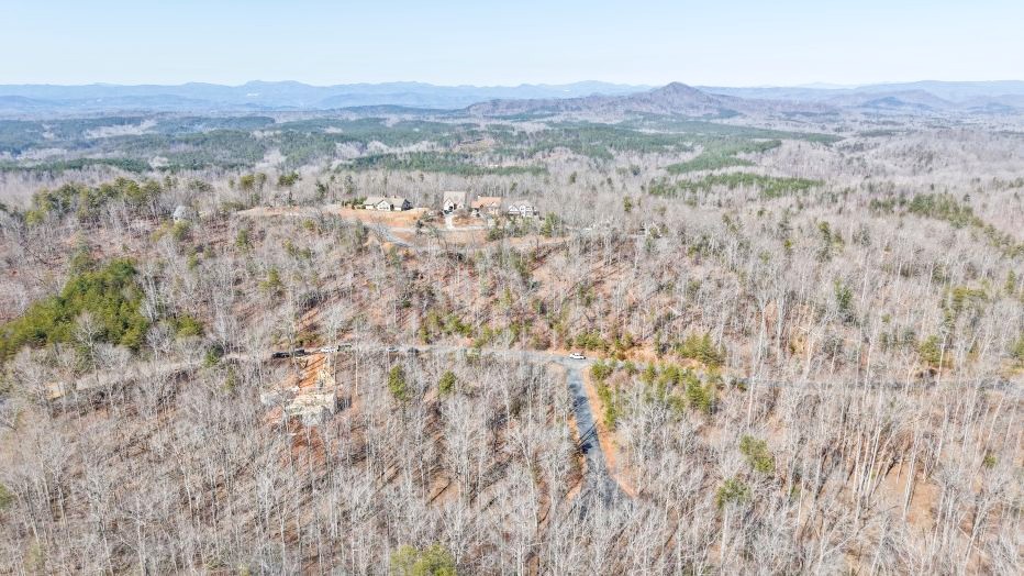8 Gabriel Way Pickens, SC 29671 - Photo 1 of 12 This elevated view captures homes nestled within a serene, expansive forested landscape, with distant mountains framing the horizon.