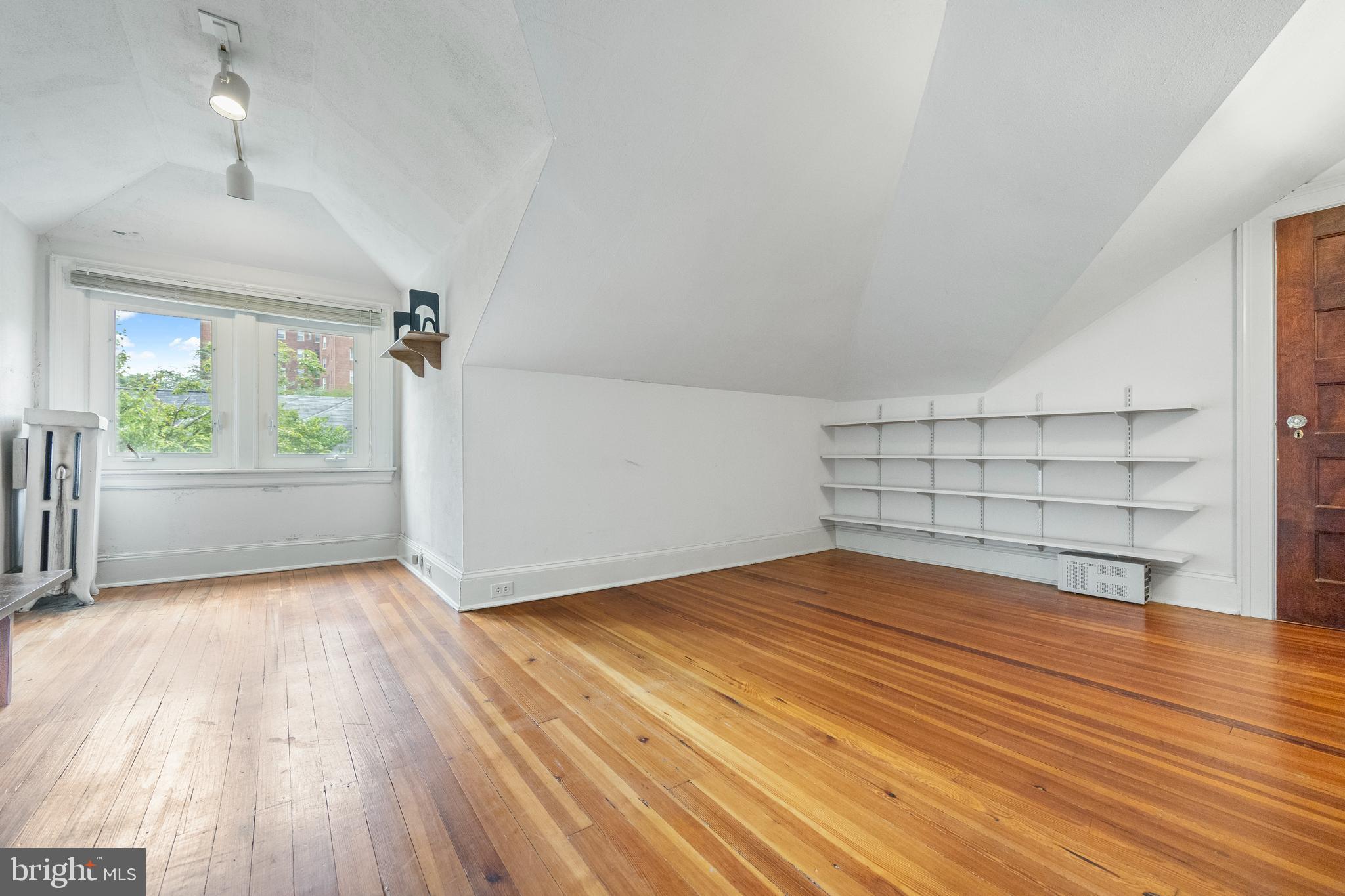 3936 Cloverhill Road Baltimore, MD 21218 - Photo 27 of 37 an empty room with wooden floor cabinet and windows