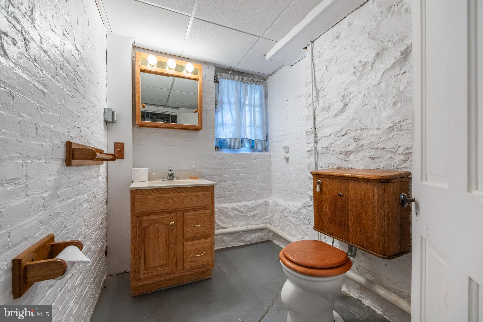 3936 Cloverhill Road Baltimore, MD 21218 - Photo 32 of 37 a bathroom with a granite countertop toilet and a sink
