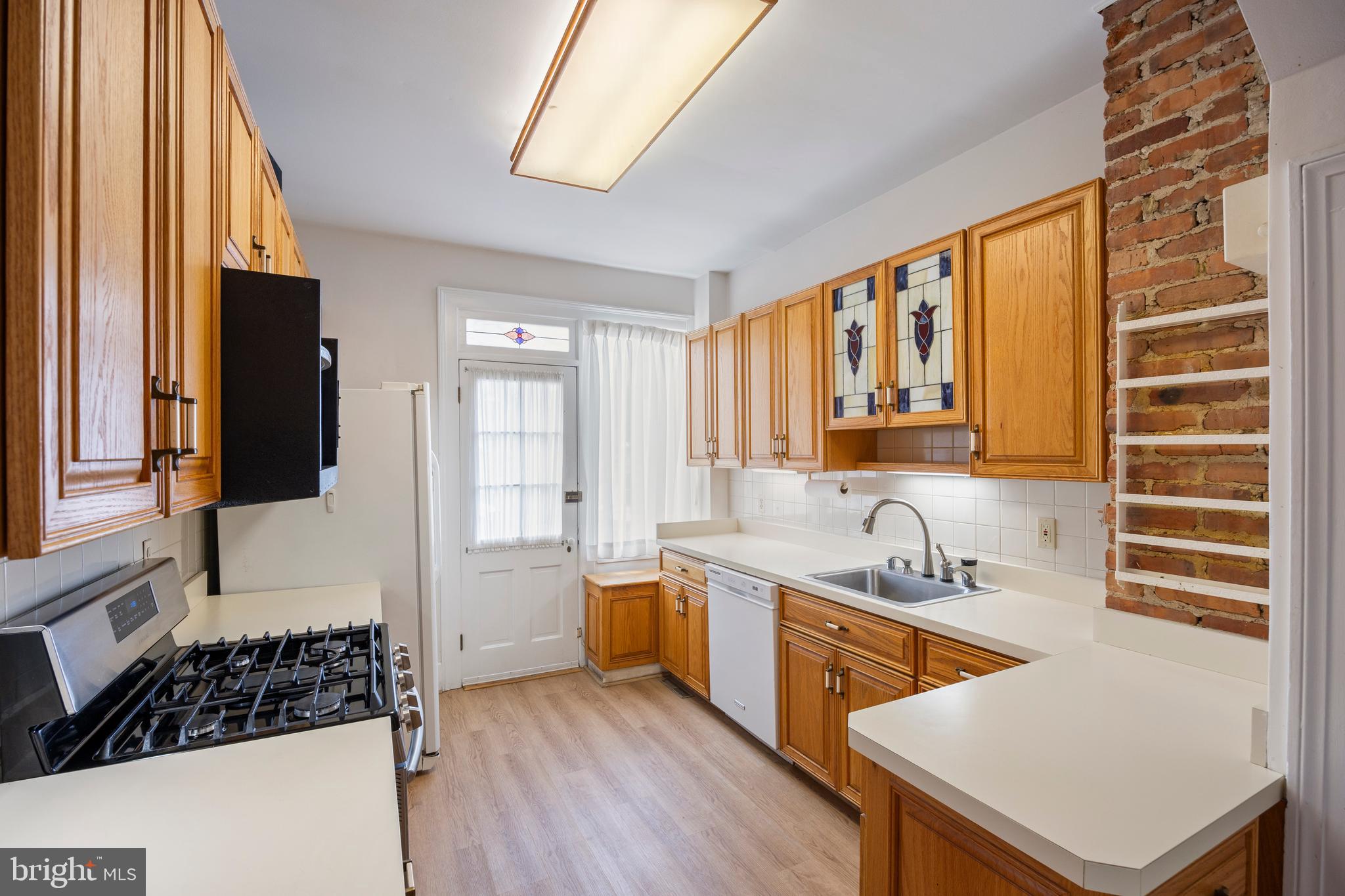 3936 Cloverhill Road Baltimore, MD 21218 - Photo 10 of 37 a kitchen with a sink a stove and a refrigerator