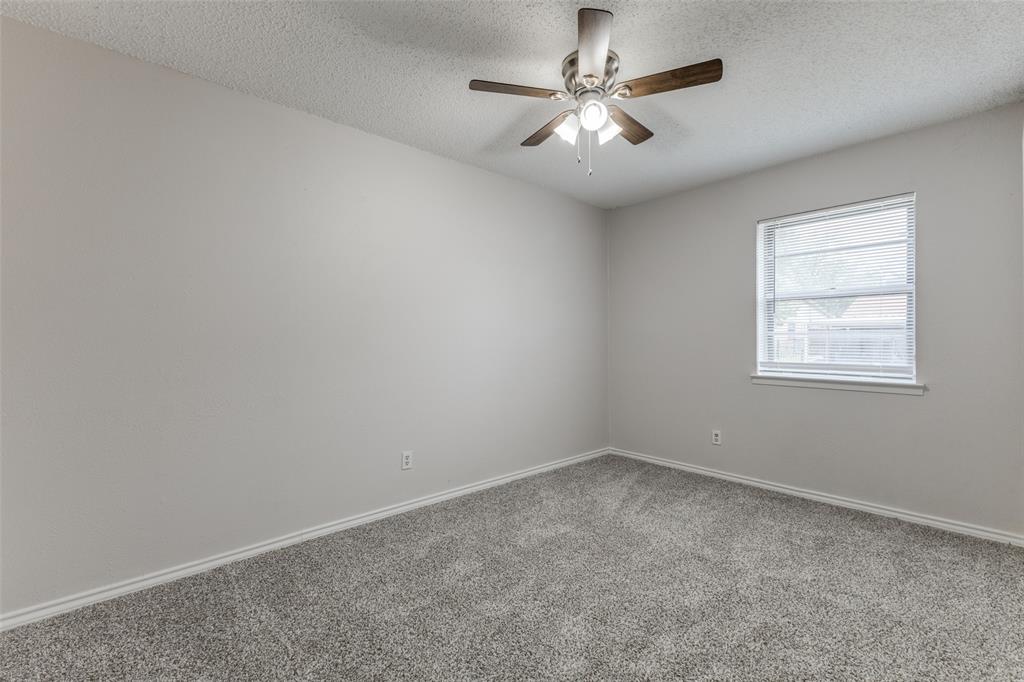 3921 Ambassador Way Balch Springs, TX 75180 - Photo 16 of 25 an empty room with a chandelier fan and windows