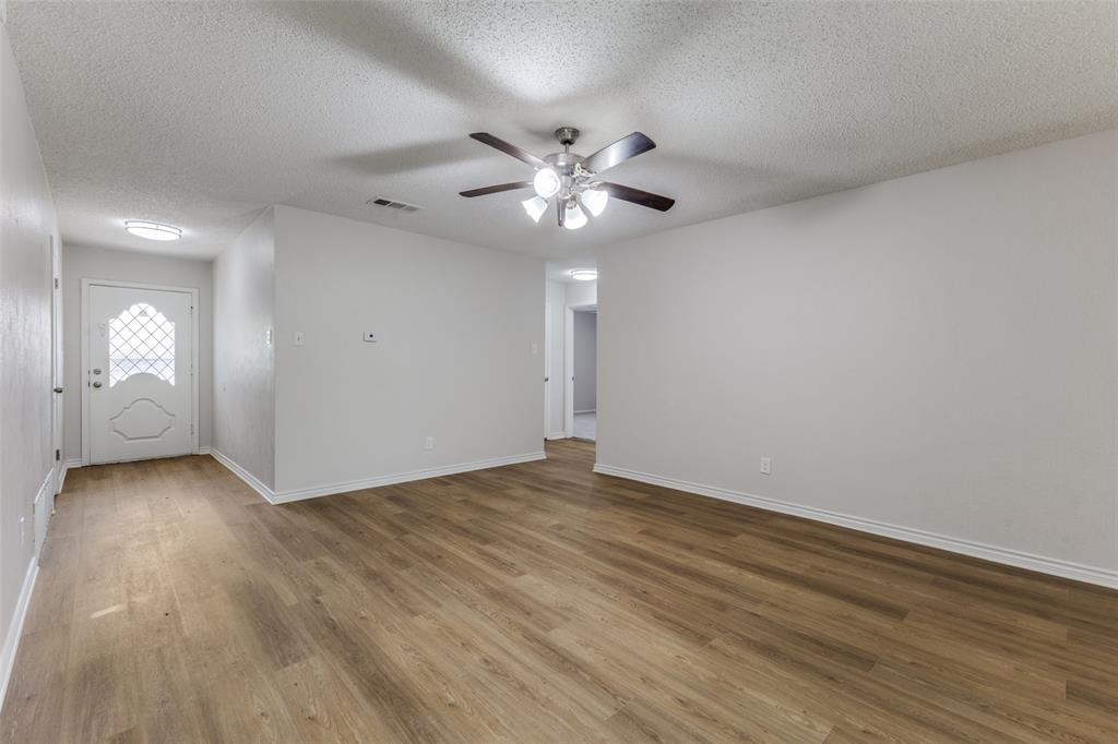 3921 Ambassador Way Balch Springs, TX 75180 - Photo 3 of 25 a view of an empty room with window and wooden floor