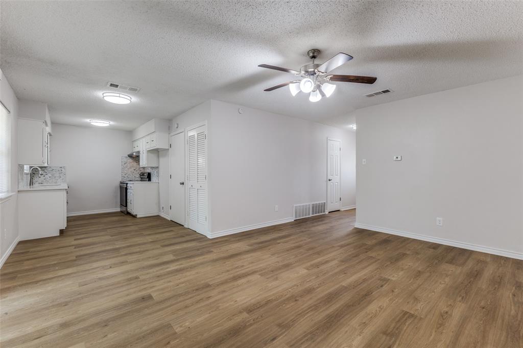 3921 Ambassador Way Balch Springs, TX 75180 - Photo 4 of 25 a view of an empty room with chandelier fan and wooden floor