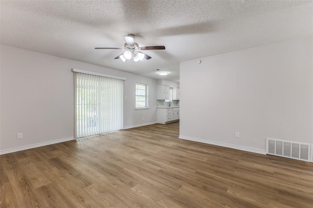 3921 Ambassador Way Balch Springs, TX 75180 - Photo 5 of 25 a view of an empty room with a window and wooden floor