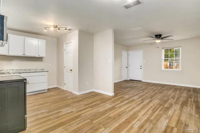 a view of a kitchen with wooden floor and a sink
