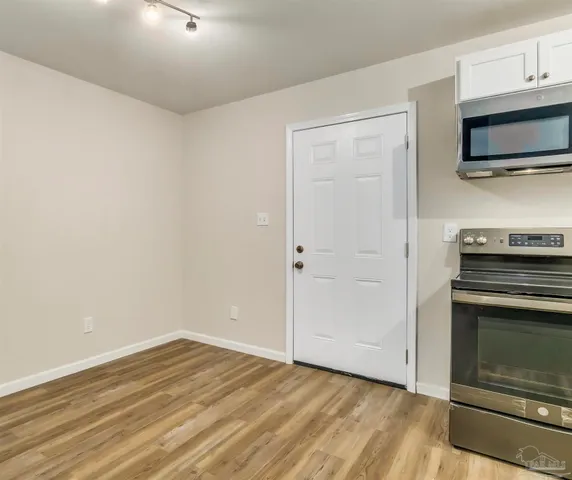 a view of a kitchen with wooden floor and electronic appliances