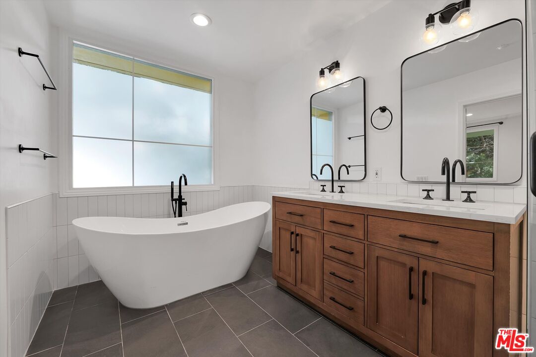 1601 South Bentley Avenue, Unit 211 Los Angeles, CA 90025 - Photo 13 of 30 a bathroom with a sink and mirror with bathtub