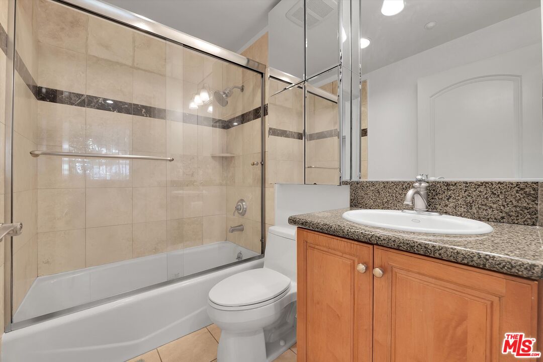 1601 South Bentley Avenue, Unit 211 Los Angeles, CA 90025 - Photo 21 of 30 a bathroom with a granite countertop sink toilet and shower
