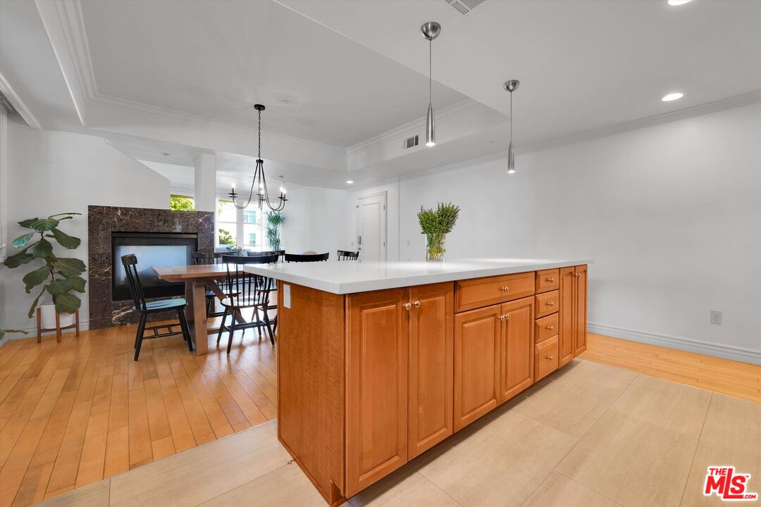 1601 South Bentley Avenue, Unit 211 Los Angeles, CA 90025 - Photo 5 of 30 a kitchen with stainless steel appliances granite countertop a kitchen island a stove a table and chairs with wooden floor