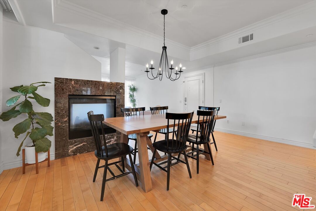 1601 South Bentley Avenue, Unit 211 Los Angeles, CA 90025 - Photo 6 of 30 a dining room with furniture a chandelier and wooden floor