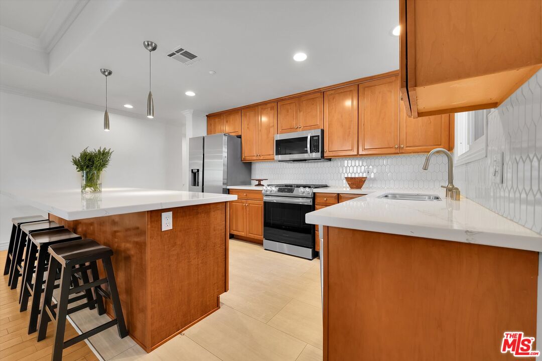 1601 South Bentley Avenue, Unit 211 Los Angeles, CA 90025 - Photo 7 of 30 a kitchen with stainless steel appliances a sink a stove top oven a counter space and cabinets