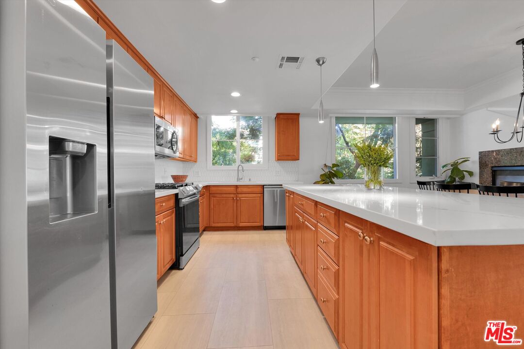 1601 South Bentley Avenue, Unit 211 Los Angeles, CA 90025 - Photo 8 of 30 a kitchen with stainless steel appliances granite countertop a sink a counter top space a large window and stainless steel appliances