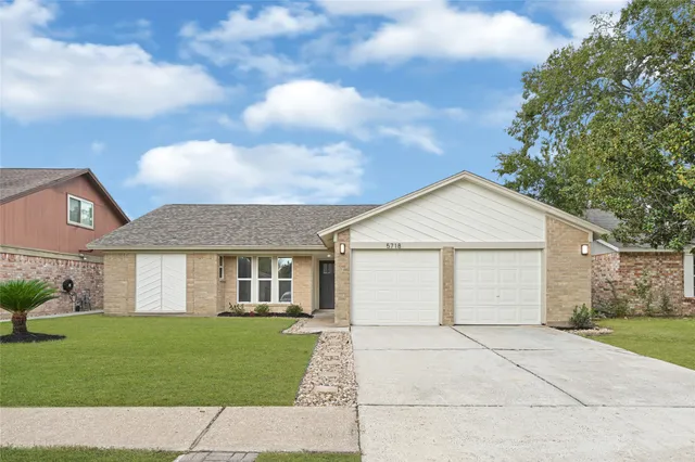 a view of a white house next to a yard and trees
