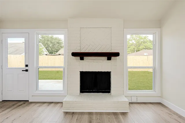 a living room with a fireplace and windows