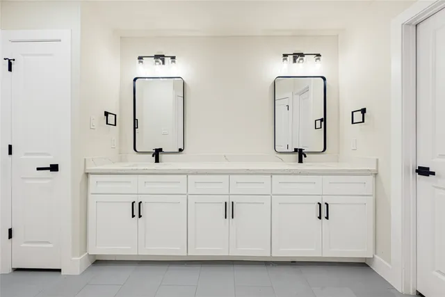 a bathroom with double vanity sinks and a mirror