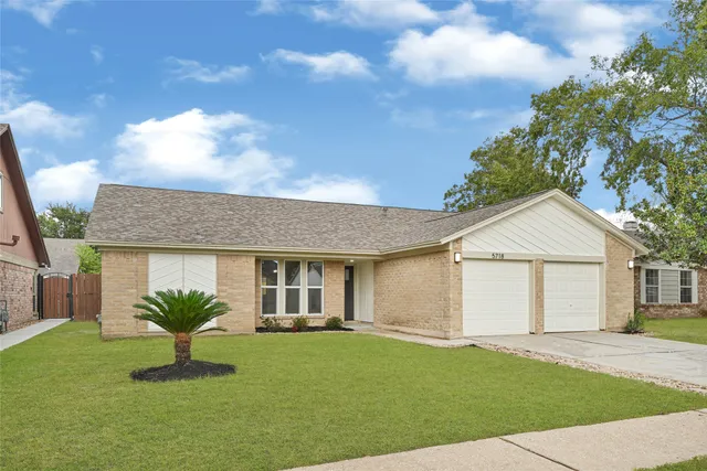 a view of a yard in front of a house with a garden