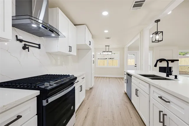 a kitchen with granite countertop a sink stove and cabinets