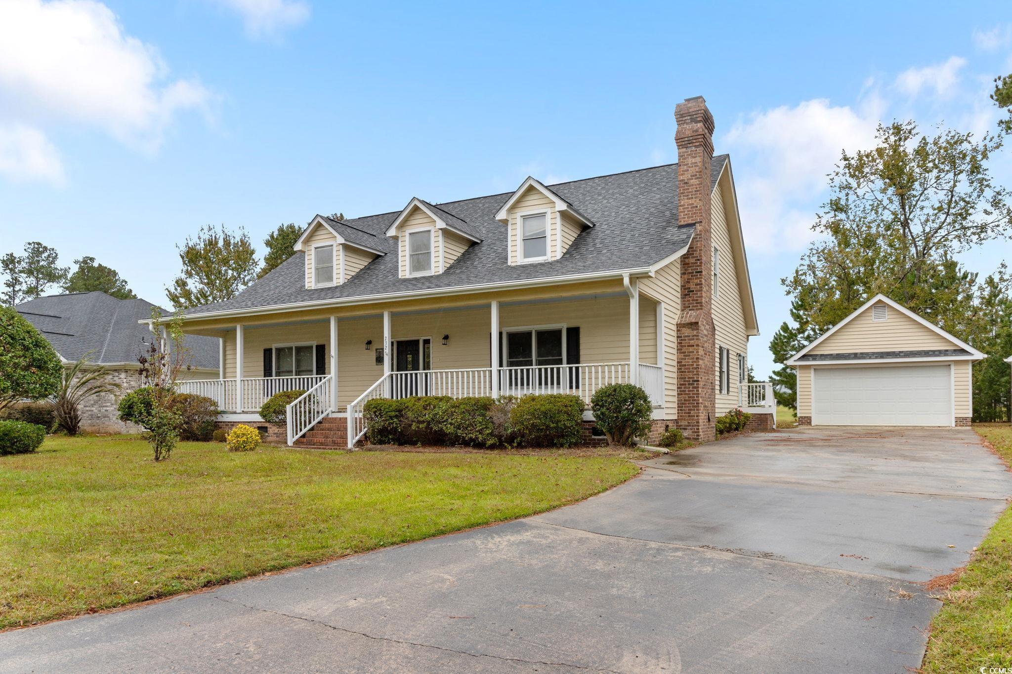 2321 Brick Drive Longs, SC 29568 - Photo 2 of 40 Cape cod-style house with an outbuilding, a front yard, a garage, covered porch, and a chimney