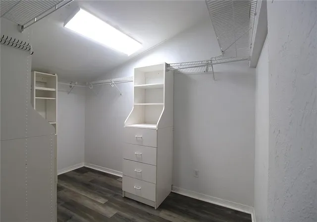 a view of walk in closet with empty racks