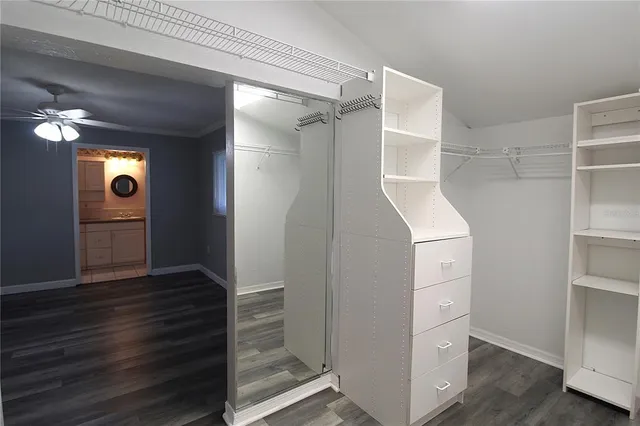 a view of empty room with wooden floor and fan