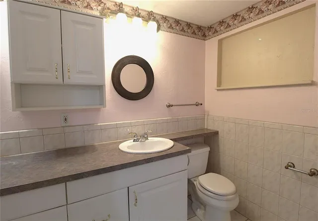 a bathroom with a sink a toilet and a mirror