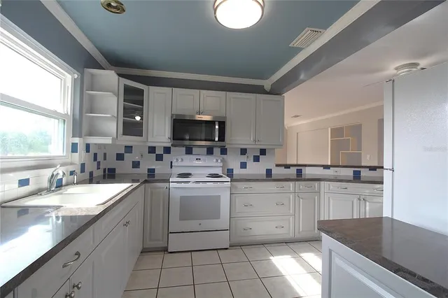 a large kitchen with stainless steel appliances granite countertop a sink and cabinets
