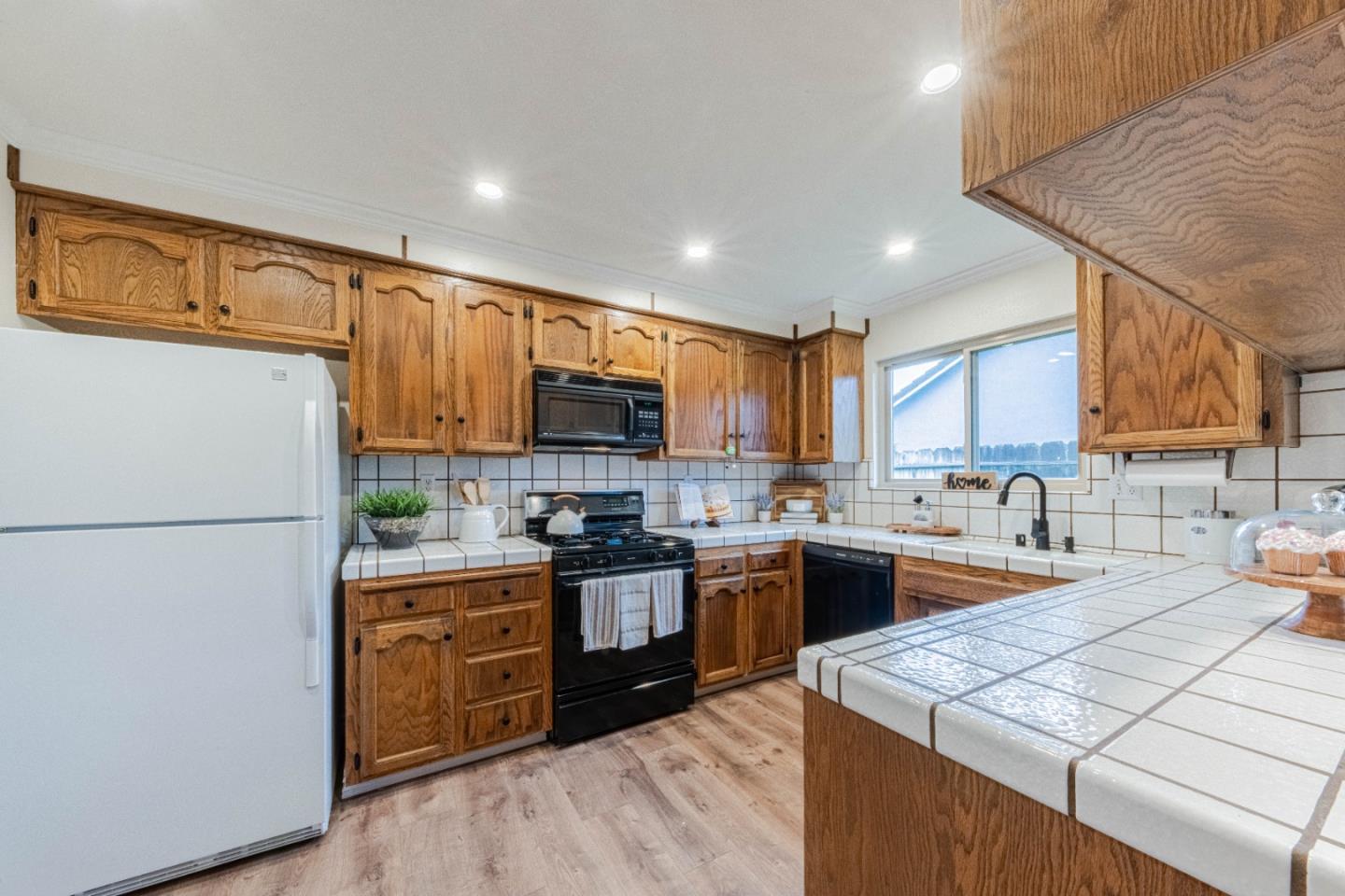 1130 Montecito Circle Salinas, CA 93901 - Photo 15 of 32 a kitchen with stainless steel appliances granite countertop a stove top oven a sink a refrigerator white cabinets and wooden floor