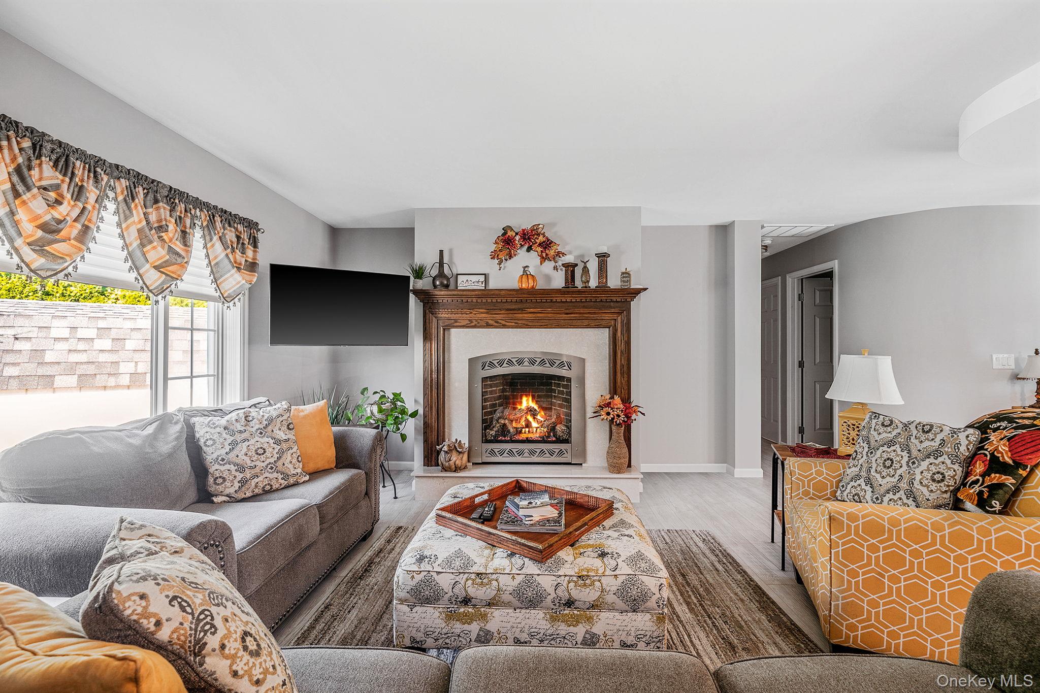 1407 Middle Road, Unit 258 Calverton, NY 11933 - Photo 15 of 50 a living room with furniture and a fireplace