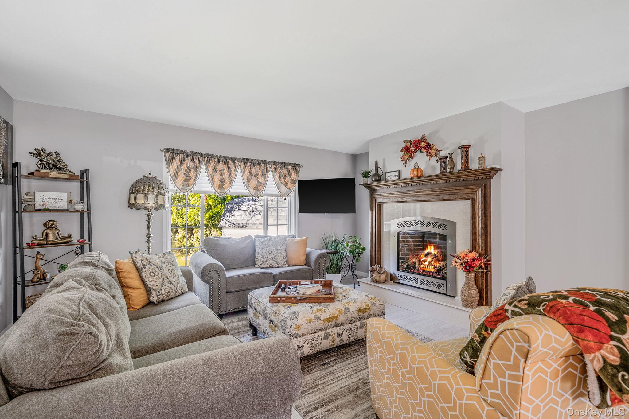 1407 Middle Road, Unit 258 Calverton, NY 11933 - Photo 16 of 50 a living room with furniture and a fireplace
