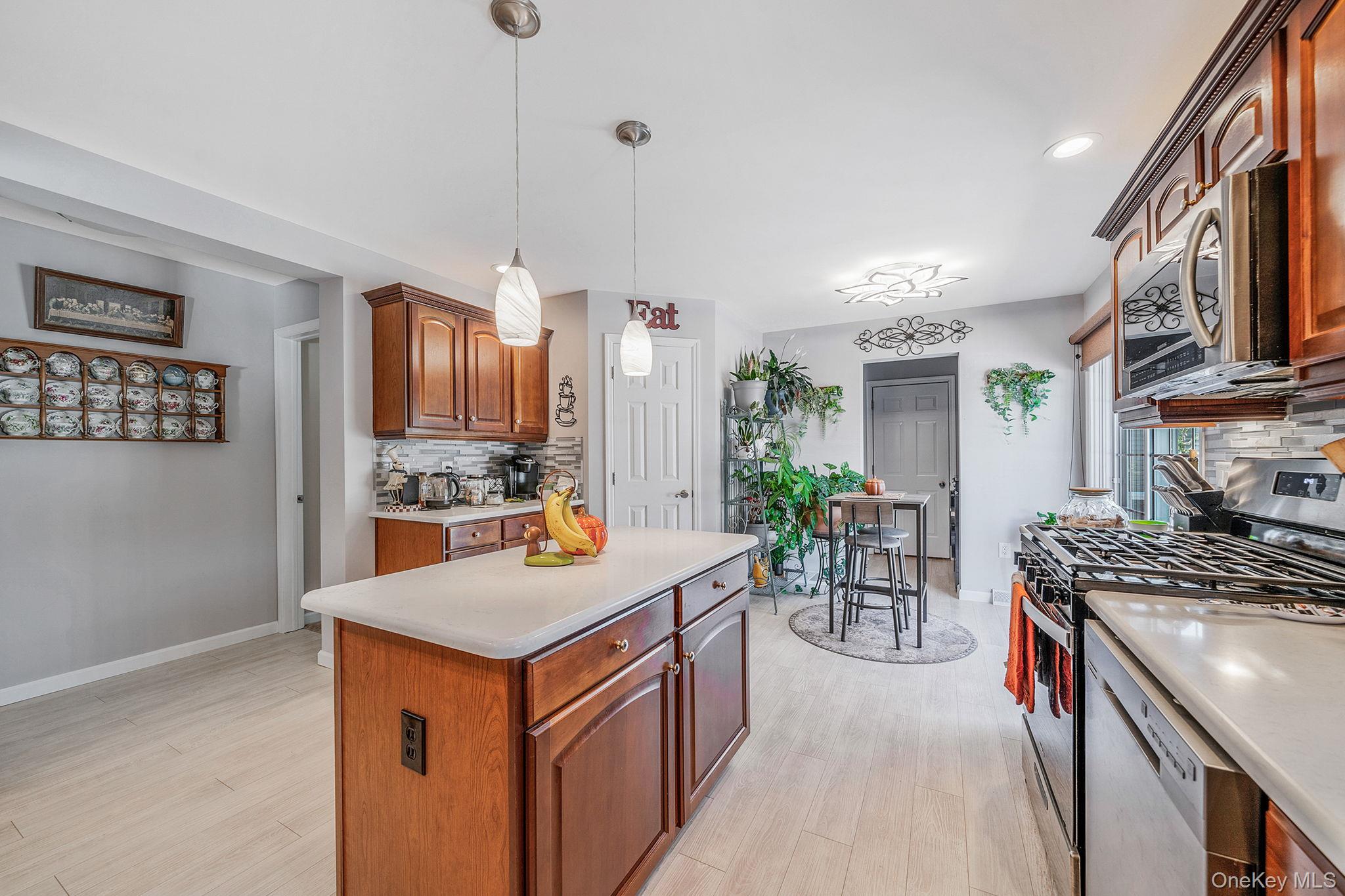 1407 Middle Road, Unit 258 Calverton, NY 11933 - Photo 20 of 50 a kitchen with stainless steel appliances granite countertop a stove and a refrigerator