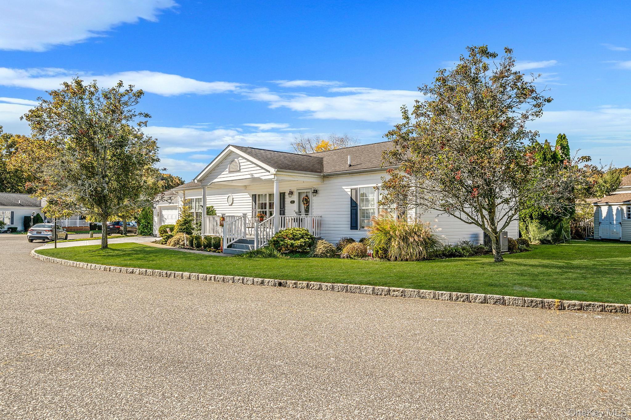 1407 Middle Road, Unit 258 Calverton, NY 11933 - Photo 2 of 50 a front view of a house with a yard and trees