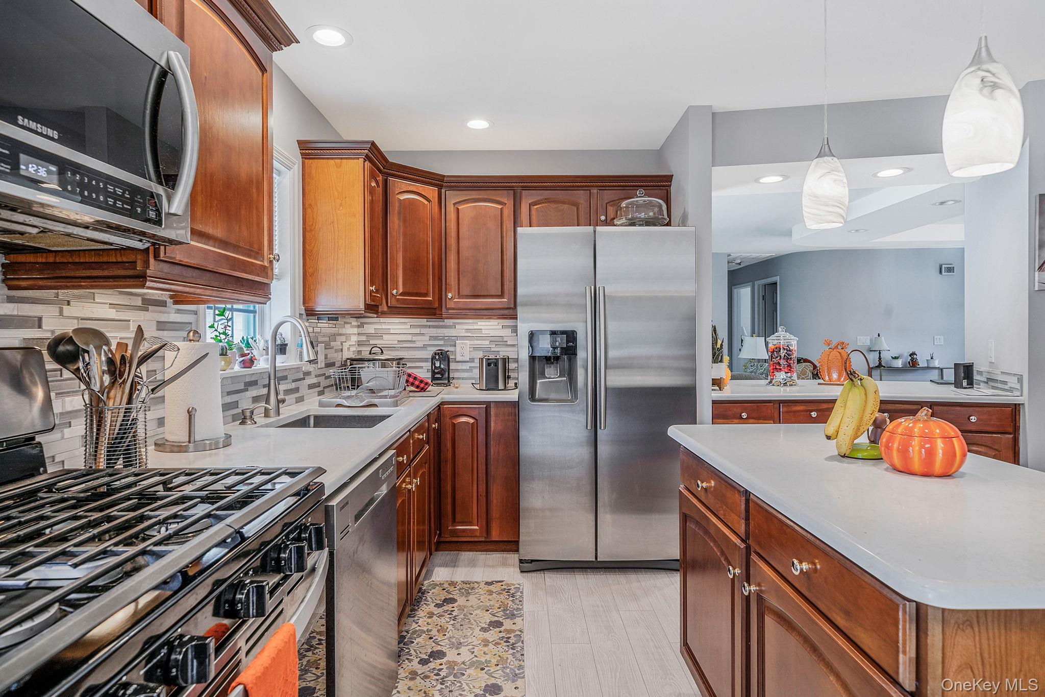 1407 Middle Road, Unit 258 Calverton, NY 11933 - Photo 21 of 50 a kitchen with stainless steel appliances granite countertop a sink stove and refrigerator
