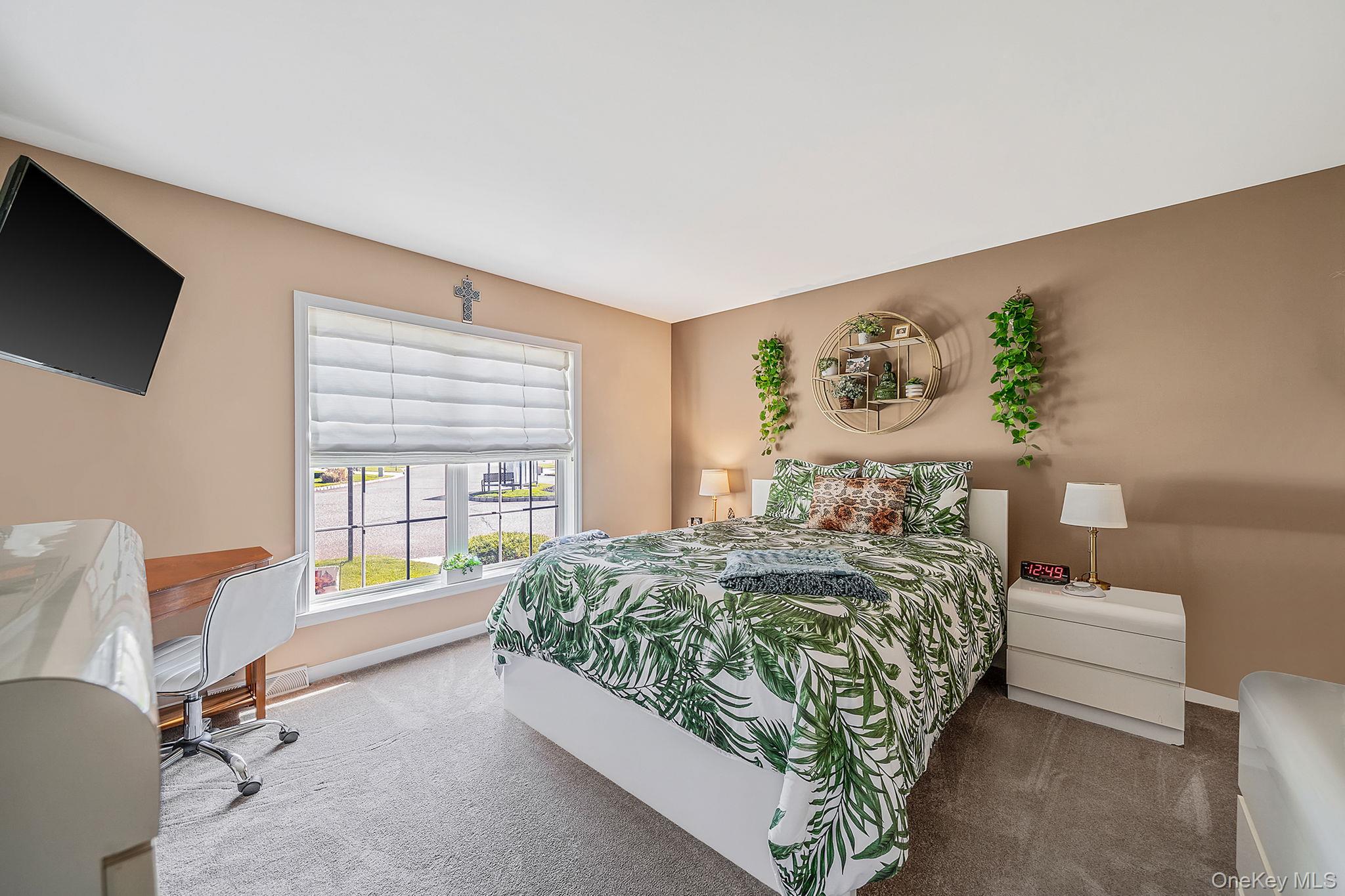 1407 Middle Road, Unit 258 Calverton, NY 11933 - Photo 26 of 50 a bedroom with a bed window and table