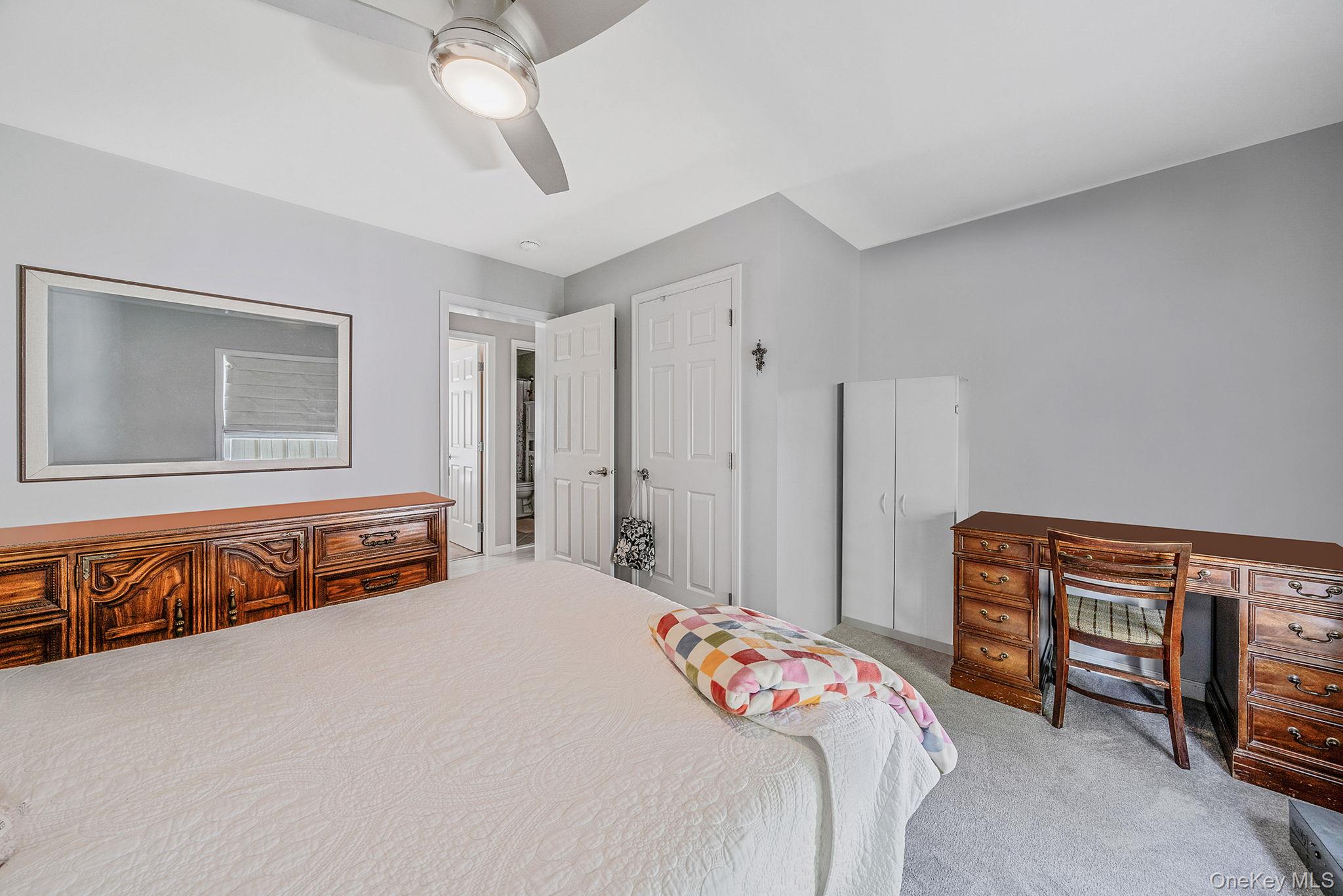 1407 Middle Road, Unit 258 Calverton, NY 11933 - Photo 31 of 50 a bedroom with a bed and a chandelier