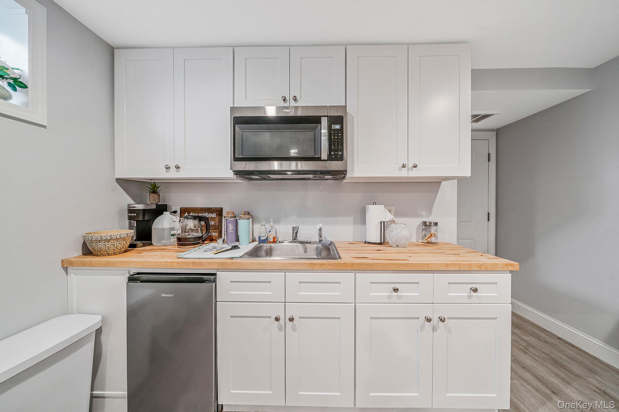 1407 Middle Road, Unit 258 Calverton, NY 11933 - Photo 35 of 50 a kitchen with white cabinets and white appliances