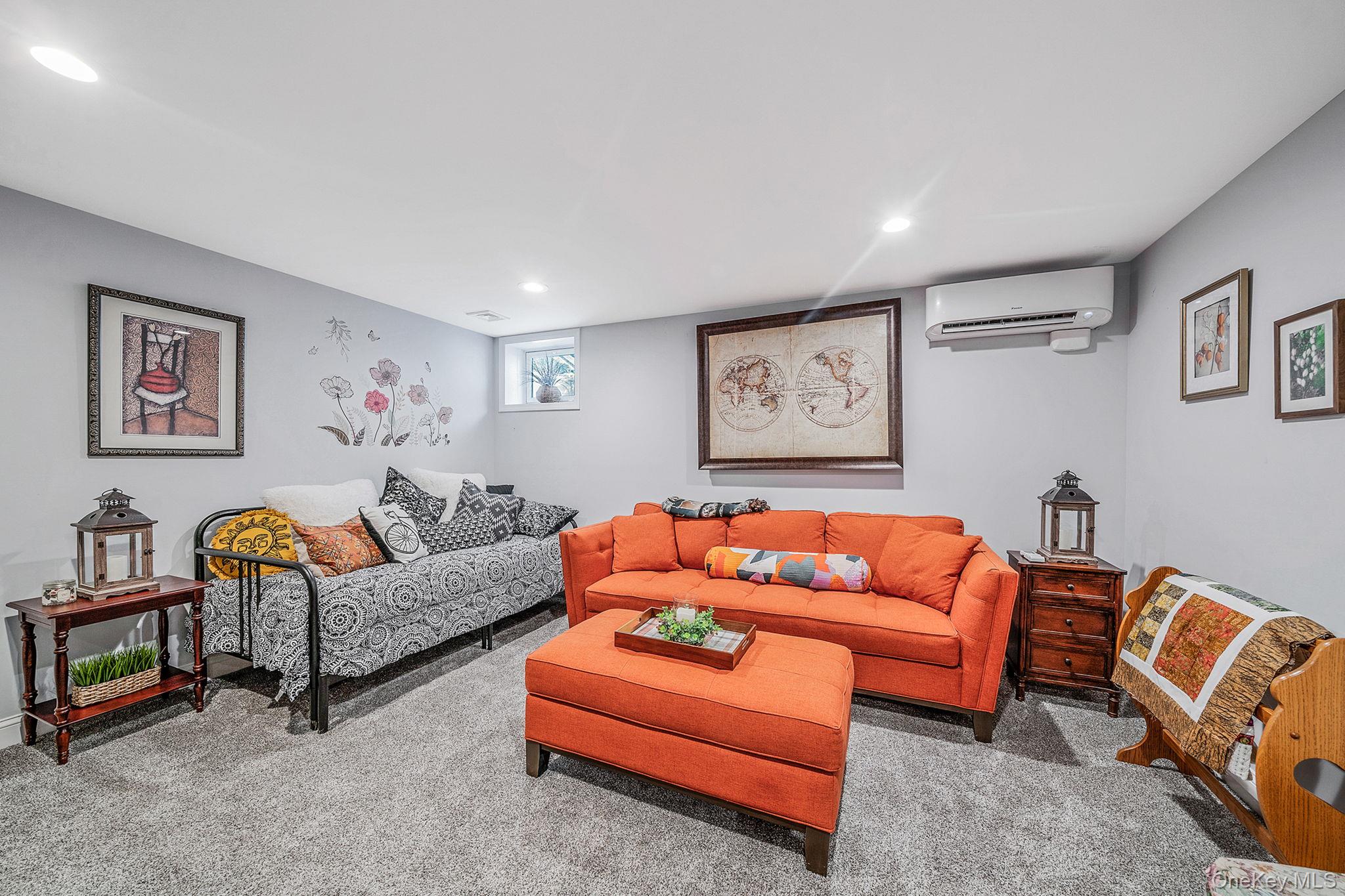 1407 Middle Road, Unit 258 Calverton, NY 11933 - Photo 39 of 50 a blue couch sitting in a living room with couch and painting on the wall