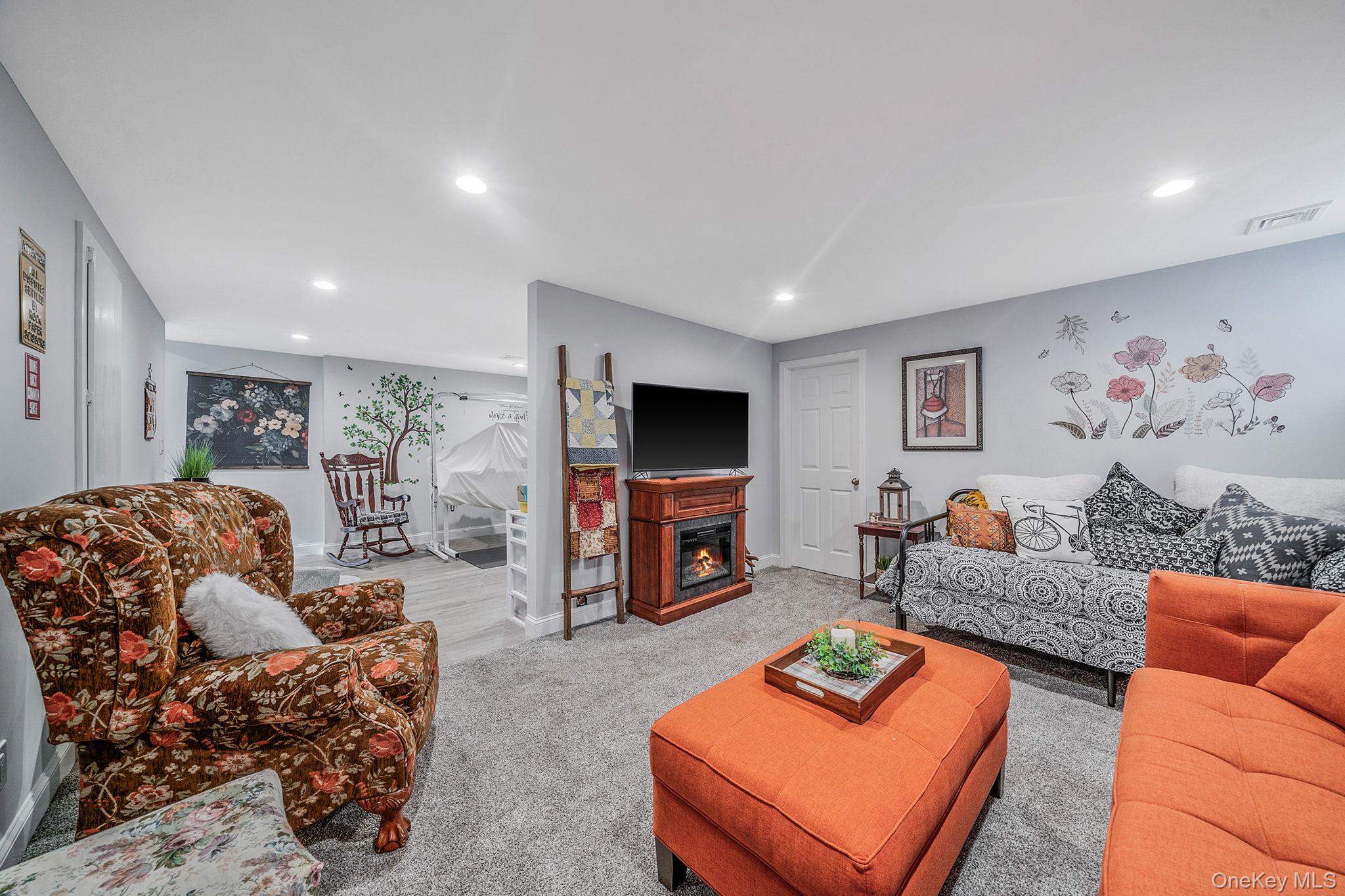 1407 Middle Road, Unit 258 Calverton, NY 11933 - Photo 40 of 50 a living room with furniture and a flat screen tv
