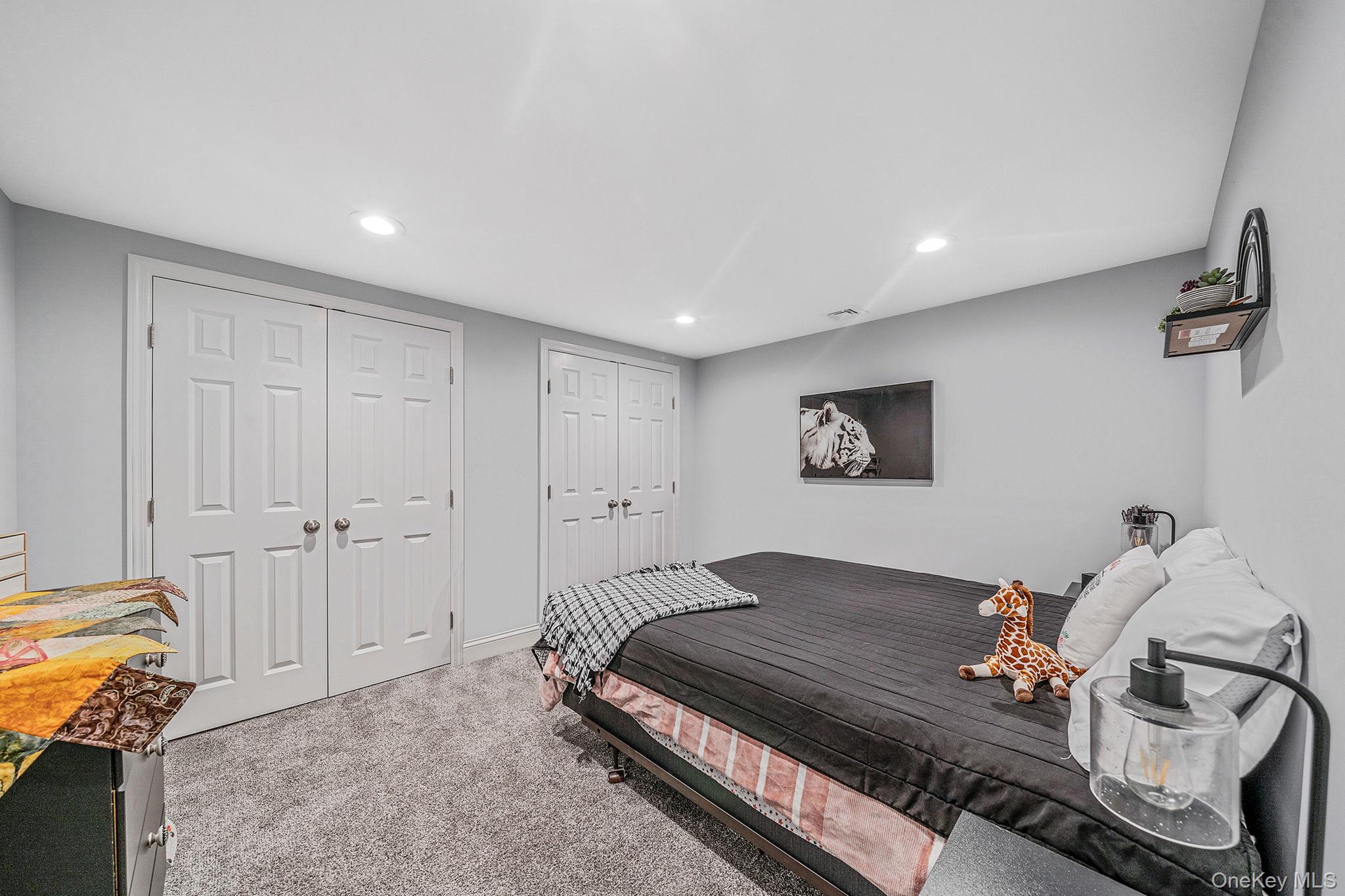 1407 Middle Road, Unit 258 Calverton, NY 11933 - Photo 41 of 50 a bedroom with a bed and wooden floor